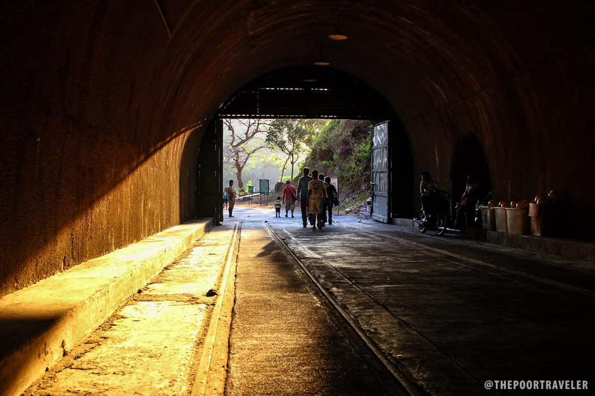 At the end of the tunnel, there are more tourists.